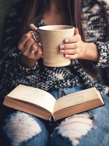 girl-having-a-break-with-cup-of-fresh-coffee-after-46BEHL3 Woman reading book with a coffee cup